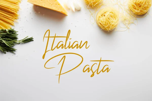 Vista superior de romero, ajo, queso y pasta sobre fondo blanco, ilustración de pasta italiana - foto de stock