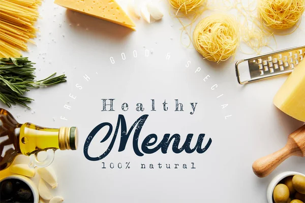 Вид сверху на булавку, терку, бутылку оливкового масла, пасту и ингредиенты на белом фоне, иллюстрация здорового меню — стоковое фото
