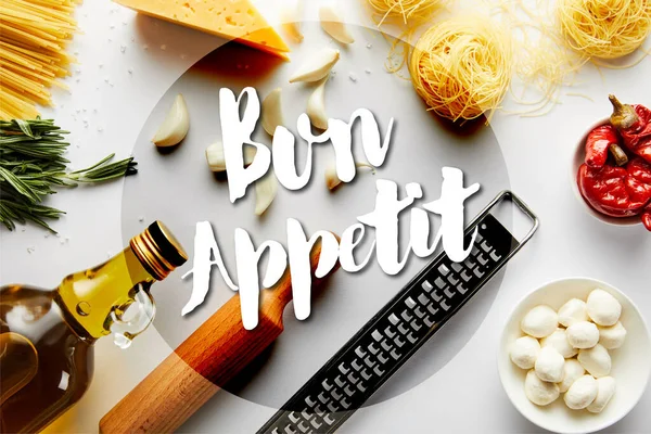 Top view of rolling pin, bottle of olive oil, grater, pasta and ingredients on white, bon appetit illustration — Stock Photo