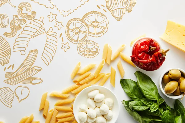 Верхний вид макарон, листья базилика, сыр и миски с оливками, маринованный перец чили и моцарелла на белом фоне, пищевая иллюстрация — стоковое фото