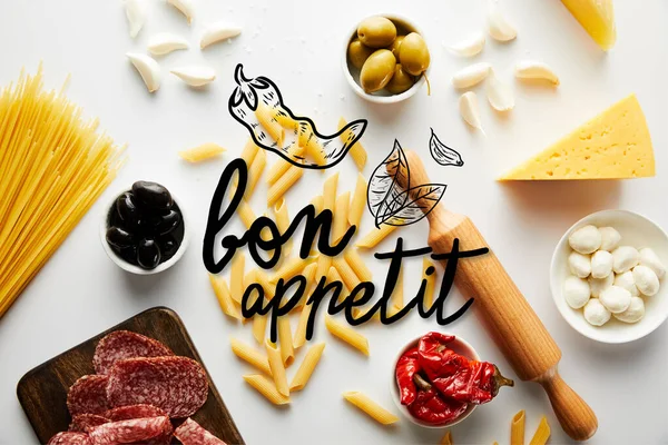 Top view of meat platter, rolling pin, pasta and ingredients on white background, bon appetit illustration — Stock Photo