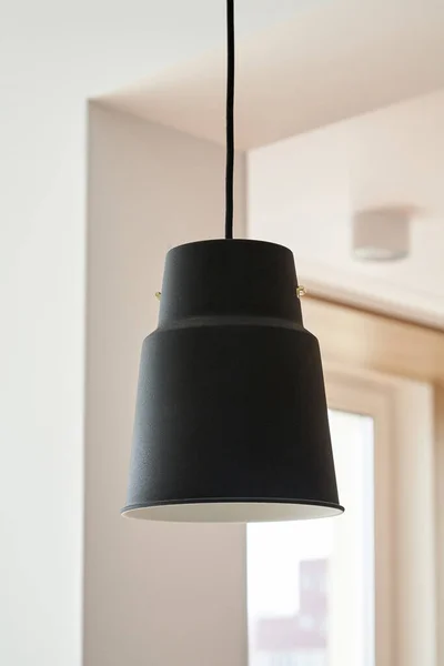 Lampe noire suspendue près des murs blancs dans l'appartement — Photo de stock