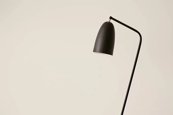 Black lamp against white wall in apartment — Stock Photo