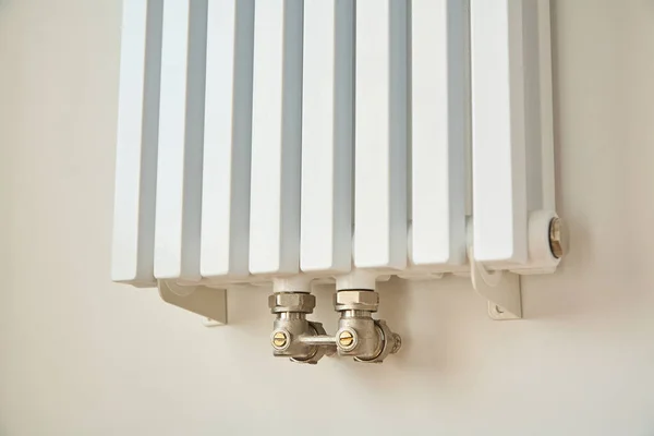 Современный радиатор отопления возле белой стены в квартире — стоковое фото
