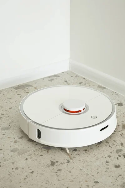 Robotic vacuum cleaner washing floor tiles near white walls — Stock Photo