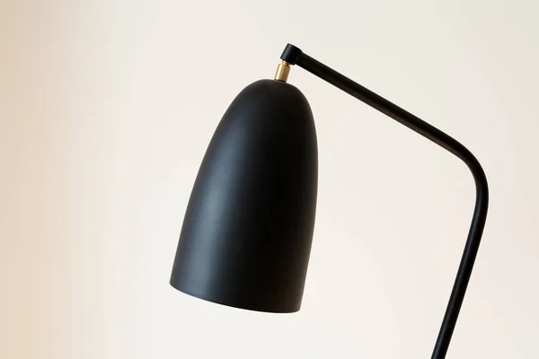 Lampe noire et moderne près du mur blanc — Photo de stock