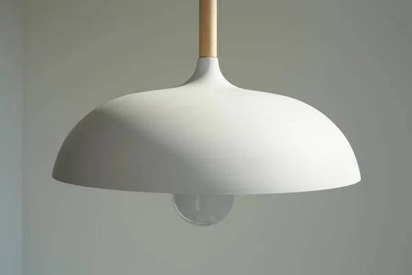 Close up of white and modern lamp with light bulb near wall — Stock Photo