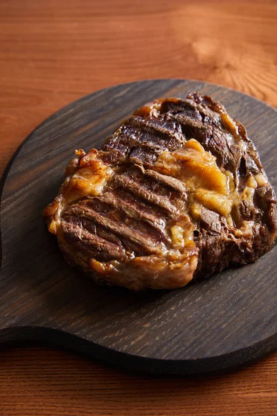 Tasty grilled steak served on wooden board — Stock Photo