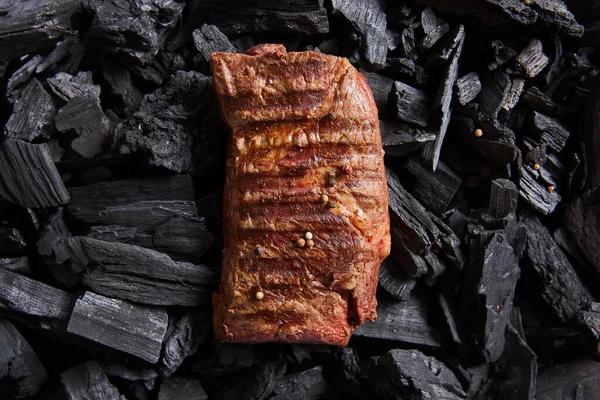 Vista superior de bife fresco grelhado saboroso em carvão preto — Stock Photo