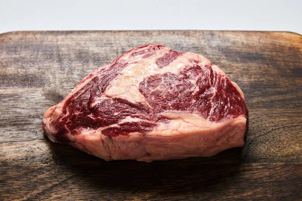 Fresh raw steak on wooden cutting board — Stock Photo