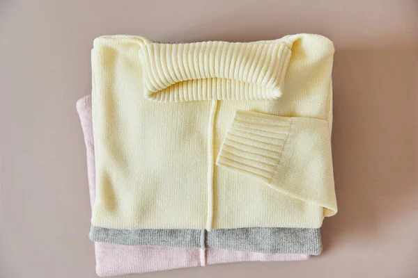 Vue de dessus des pulls doux en maille rose, beige et gris — Photo de stock