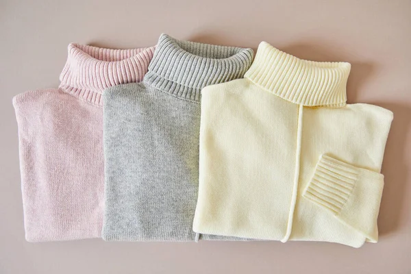 Top view of pink, beige and grey knitted soft sweaters — Stock Photo