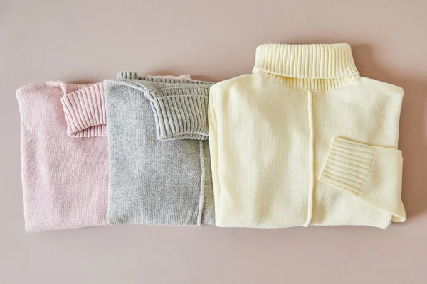 Vue de dessus des pulls doux en maille rose, beige et gris — Photo de stock