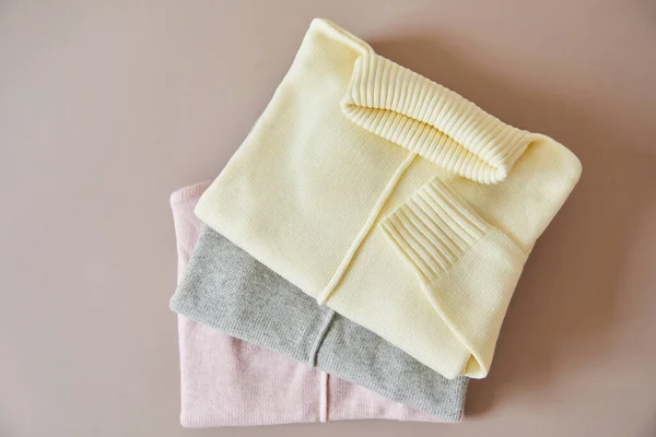 Vue de dessus des pulls doux en maille rose, beige et gris — Photo de stock