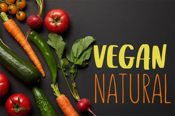 Draufsicht auf rohes, schmackhaftes Gemüse mit grünen Blättern auf schwarzem Hintergrund mit veganer natürlicher Illustration — Stockfoto