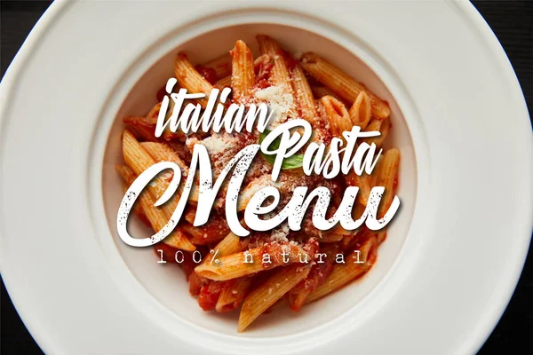 Верхний вид вкусной пасты болоньезе с томатным соусом и пармезан в белой тарелке изолирован на черной, итальянской иллюстрации меню пасты — стоковое фото
