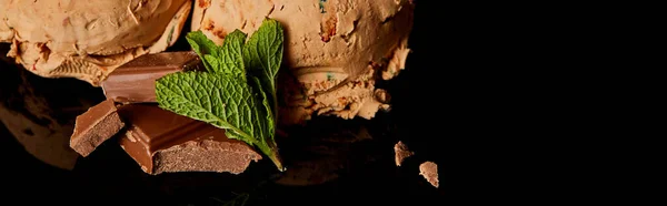 Close up view of fresh delicious chocolate ice cream with mint leaves isolated on black, panoramic orientation — Stock Photo