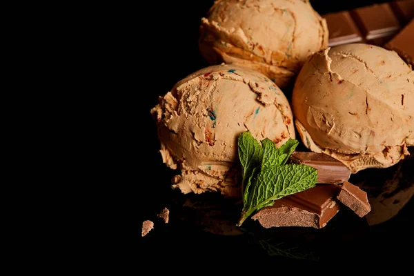 Fresh delicious chocolate ice cream with mint leaves isolated on black — Stock Photo