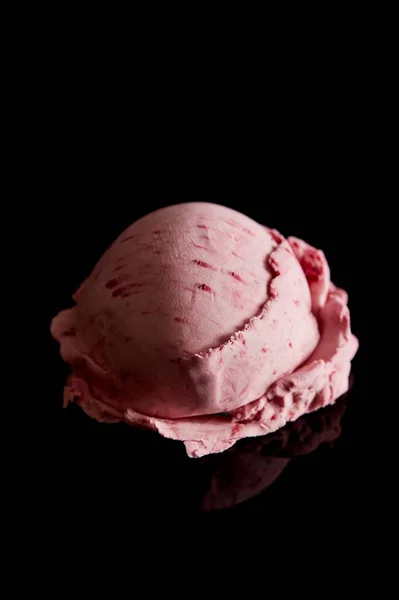 Вкусное розовое клубничное мороженое, изолированное на черном — стоковое фото