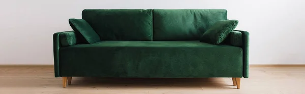 Modern green sofa with pillows in room, panoramic shot — Stock Photo