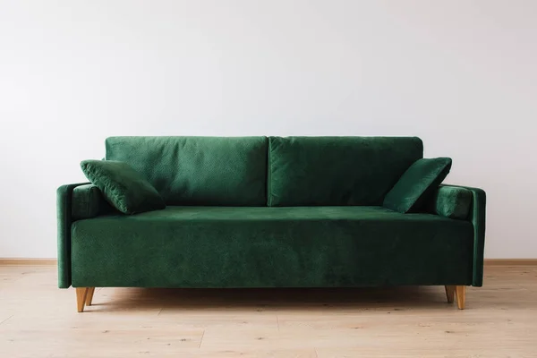 Modern green sofa with pillows in room — Stock Photo