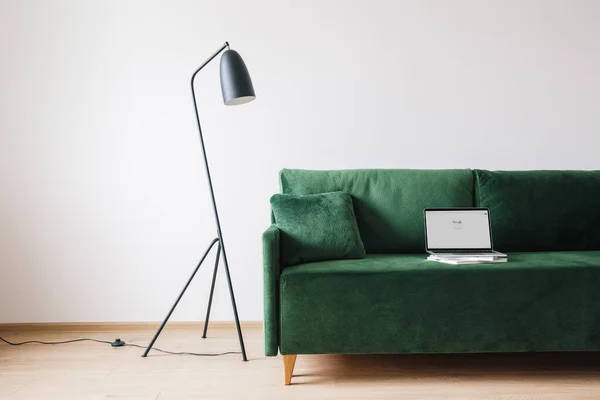 KYIV, UKRAINE - APRIL 14, 2020: green sofa with pillow and laptop with google website on screen near metal modern floor lamp — Stock Photo