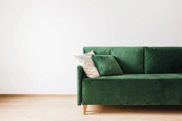 Modern green sofa with pillows in spacious room — Stock Photo