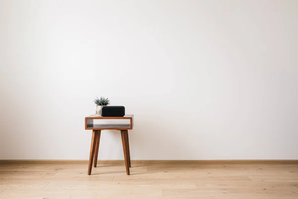 Table basse en bois avec plante et horloge avec écran blanc — Photo de stock