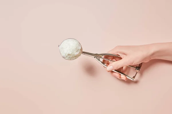 Cropped view of woman holding fresh tasty ice cream ball in scoop on pink background — Stock Photo