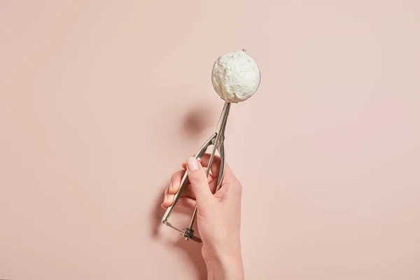 Vista recortada de la mujer sosteniendo bola de helado fresco sabroso en cucharada sobre fondo rosa - foto de stock