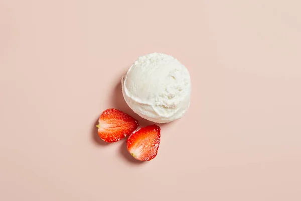 Вид сверху на свежий вкусный шарик мороженого с клубникой на розовом фоне — стоковое фото
