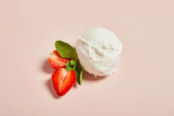 Bola de helado fresco sabroso con fresa y menta sobre fondo rosa - foto de stock