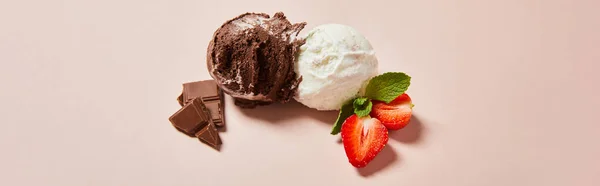 Top view of fresh tasty white and chocolate ice cream balls with mint and strawberry on pink background, panoramic shot — Stock Photo