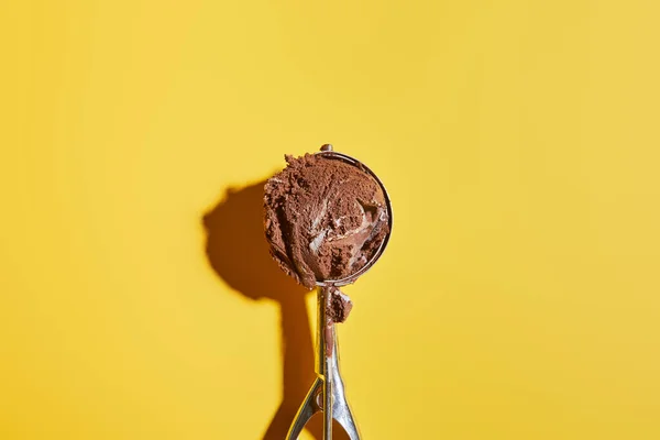 Vista dall'alto della palla di gelato al cioccolato fresco in paletta su sfondo giallo — Foto stock