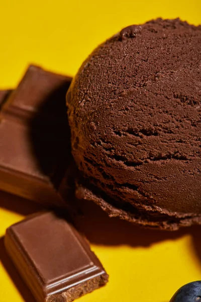 Vista de cerca de sabroso helado marrón con arándanos y chocolate - foto de stock