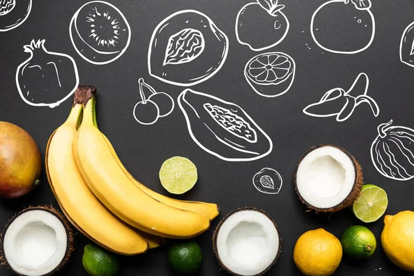 Vista superior de frutas tropicales maduras sobre fondo negro con ilustración de frutas exóticas - foto de stock