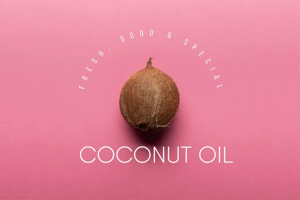 Вид зверху на весь кокос на рожевому фоні з ілюстрацією кокосової олії — стокове фото