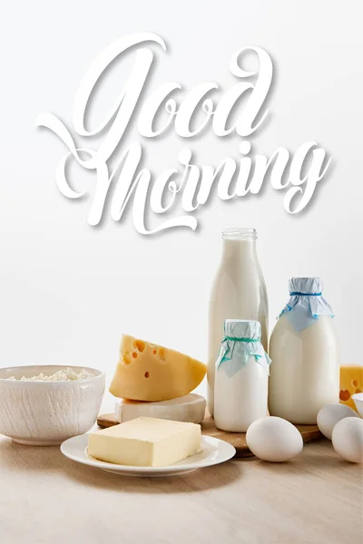 Divers produits laitiers biologiques frais et oeufs sur table en bois isolé sur blanc, illustration de bonjour — Photo de stock