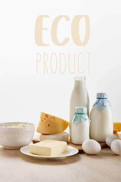 Various fresh organic dairy products and eggs on wooden table isolated on white with eco product illustration — Stock Photo