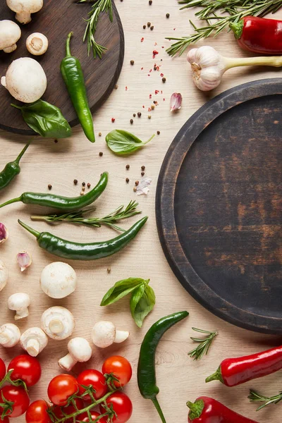 Draufsicht auf leere Tafel in der Nähe von frischem reifem Gemüse, Kräutern, Gewürzen und Pilzen auf Holztisch — Stockfoto