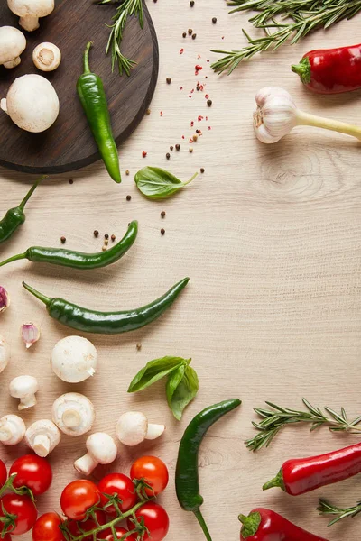 Blick von oben auf frisches reifes Gemüse, Kräuter, Gewürze und Pilze auf Holztisch — Stockfoto