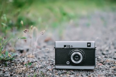 Eski retro fotoğraf makinesi çim arka plan ile yolda.