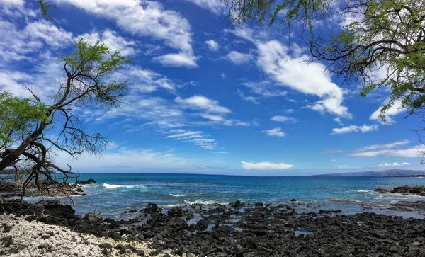 Лава рок та коралів з Spray гуркіт хвиль в хвилю басейни на Maluaka пляжі і Kihei Мауї з небо та хмари — стокове фото