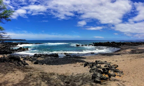 Roca de lava y coral con aerosol de olas rompiendo en piscinas de marea en la playa de Maluaka y Kihei Maui con cielo y nubes —  Fotos de Stock