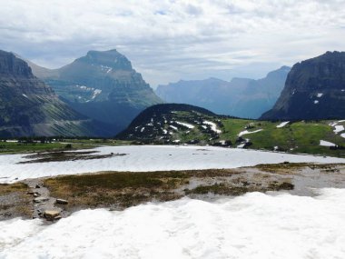 Güneş Road, yatay görünüm gidiş kar Glacier Ulusal Park dahil dağlarla çevrili ve özellikleri şelaleler, yaban hayatı, Logan Pass, saklı göl, Highline izi, çevresinde alanları: Piegan, Pollock, Oberlin, Clements, Reynolds
