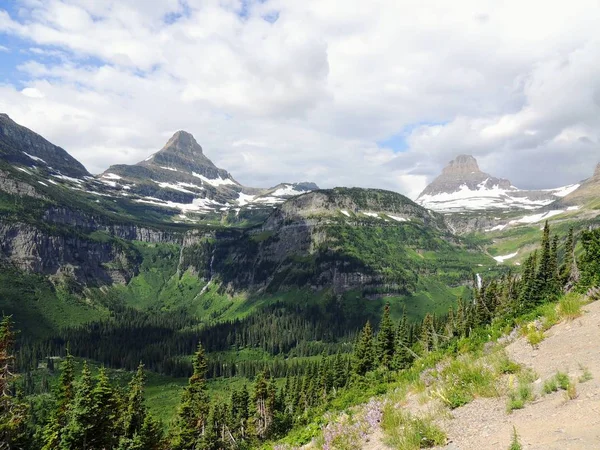 Going to the Sun Road, Vista del paisaje, campos de nieve En el Parque Nacional Glaciar alrededor de Logan Pass, Hidden Lake, Highline Trail, que cuenta con cascadas, vida silvestre, y está rodeado de montañas que incluyen: Piegan, Pollock, Oberlin, Clements, Reynolds — Foto de Stock