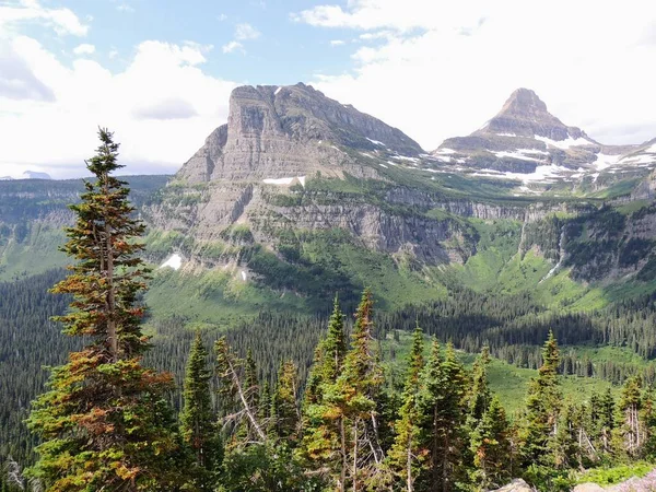 Naar de zon weg, weergave van landschap, sneeuw velden In Glacier National Park rond Logan Pass, Hidden Lake, Highline Trail, die heeft watervallen, wilde dieren, en is omgeven door bergen, met inbegrip van: Piegan, Pollock, Oberlin, Clements, Reynolds — Stockfoto