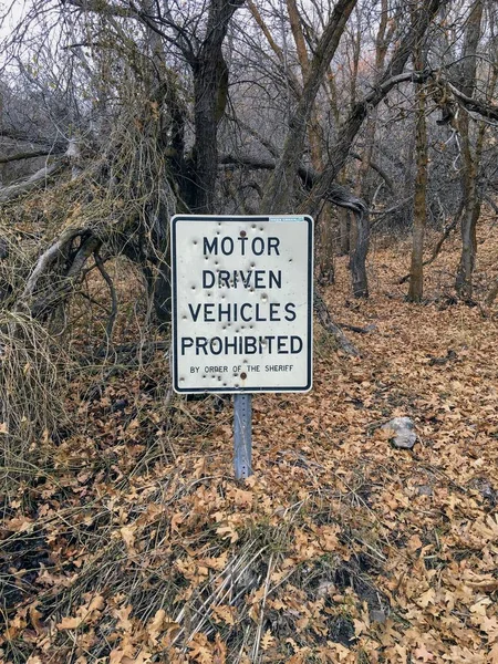 Motor Driven Vehicles Prohibited by order of the Sheriff sign with bullet holes, in forest trail on the Yellow Fork and Rose Canyon Trails in Oquirrh Mountains on the Wasatch Front in Salt Lake County Utah USA.