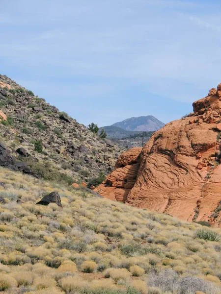 Views of sandstone and lava rock mountains and desert plants around the Red Cliffs National Conservation Area on the Yellow Knolls hiking trail located in southwest Utah, north of St. George at the northeastern-most edge of the Mojave Desert.