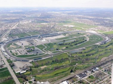 Aerial view of Indianapolis 500, an automobile race held annually at Indianapolis Motor Speedway in Speedway, Indiana through clouds. View from airplane. clipart